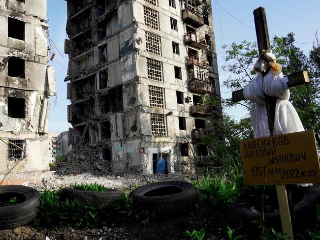 A grave is pictured in front of destroyed residential buildings in Mariupol, amid Russia’s ongoing military action in Ukraine. Picture: AFP