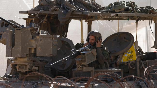 An Israeli army soldier on a tank as it drives into the UN-patrolled buffer zone, which separates Israeli and Syrian forces on the Golan Heights. Picture: AFP.