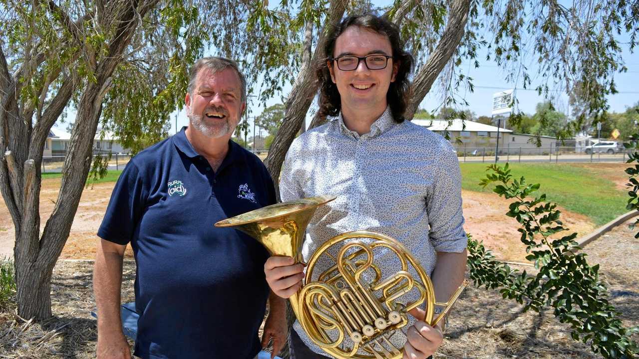 Music teacher Sam Muller (right) holds the French Horn, gifted to his student by Wayne Thompson of Rural Aid. Picture: Contributed