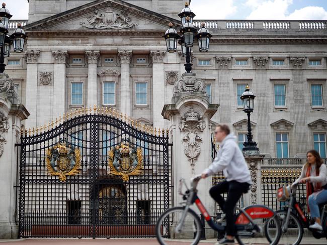 People cycle past Buckingham Palace in London on May 13, 2020, as people start to return to work after COVID-19 lockdown restrictions were eased. - Britain's economy shrank two percent in the first three months of the year, rocked by the fallout from the coronavirus pandemic, official data showed Wednesday, with analysts predicting even worse to come. Prime Minister Boris Johnson began this week to relax some of lockdown measures in order to help the economy, despite the rising death toll, but he has also stressed that great caution is needed. (Photo by Tolga Akmen / AFP)