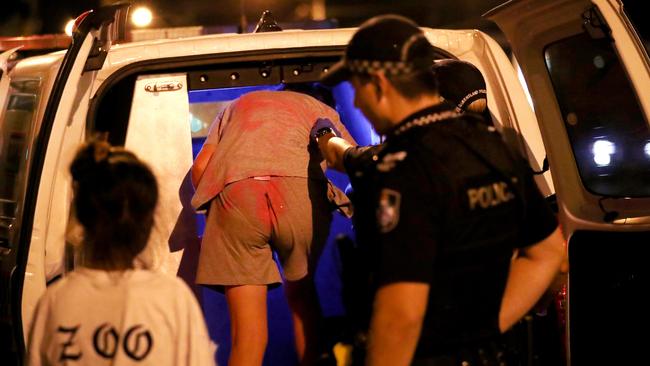 A teenage girl is escorted into the back of a police van in Townsville. Picture: Alix Sweeney.