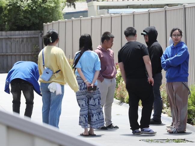 Friends and family pay their respects. Picture: David Crosling