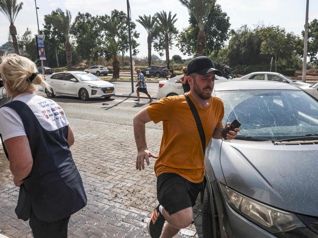 People run for cover upon hearing sirens warning of incoming fire in the southern Israeli city of Ashkelon. Picture: AFP