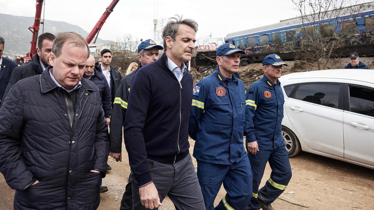 Greece’s transport minister Kostas Karamanls (left) and Greek prime minister Kyriakos Mitsotakis (centre) visit the crash site. Picture: AFP/Greek Prime Minister’s Office