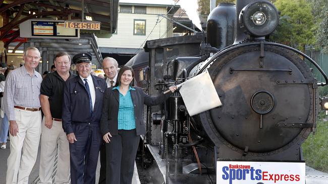 Former Bankstown MP Doug Shedden, left, during a Bankstown Sports promotion at the station, with present Bankstown MP Tania Mihailuk with the signal flag.