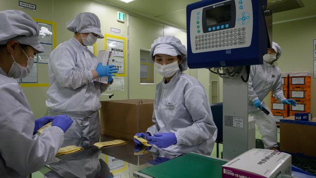 Coronavirus testing kits being packaged on a production line . Picture: ED JONES / AFP