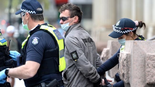 Police arrest a man on the corner of Elizabeth and Bourke streets. Picture: Andrew Henshaw