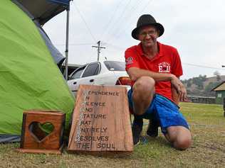 OUR SAVIOUR: Displaced Terania Creek residents Declan and Terri said local man Michael Ryan (pictured) has been their saviour. Michael crafted this beautiful wooden sign to help raise their spirits while they were camping at the showgrounds. Picture: Jackie Munro