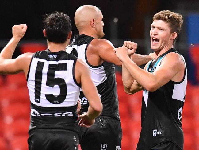 Mitch Georgiades (right) of the Power celebrates kicking a goal with team mates during the Round 1 AFL match between the Gold Coast Suns and Port Adelaide Power at Metricon Stadium on the Gold Coast, Saturday, March 21, 2020. (AAP Image/Darren England) NO ARCHIVING, EDITORIAL USE ONLY