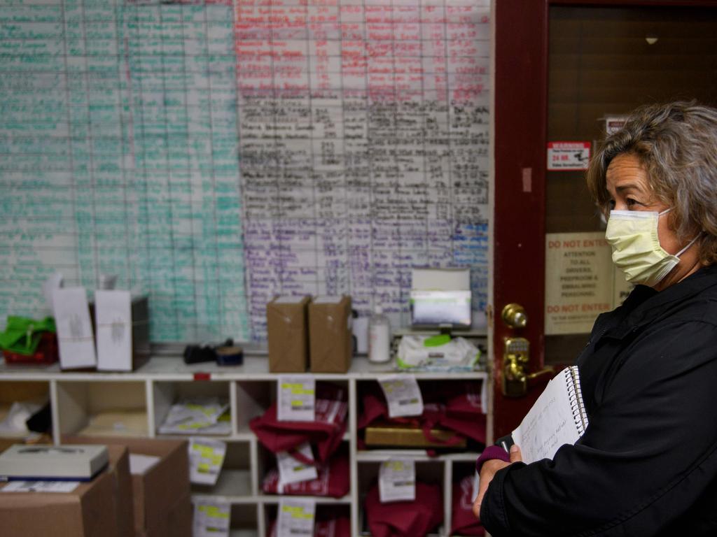 LA funeral home director Magda Maldonado stands in front of a board filled with the names of people awaiting services. Picture: AFP