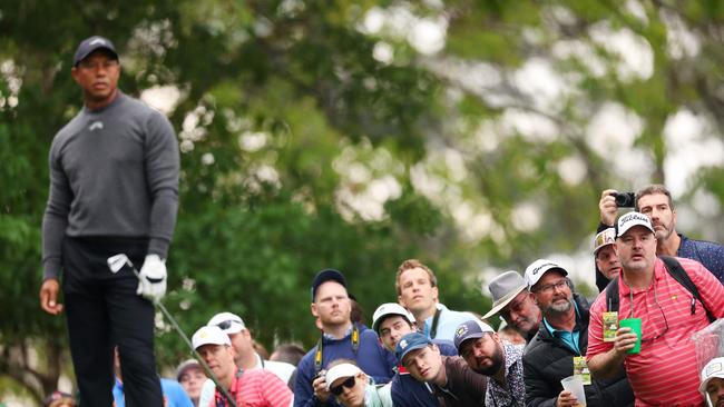 Patrons watch a shot played by Tiger Woods of the United States during a practice round prior to the 2024 Masters Tournament at Augusta National Golf Club.