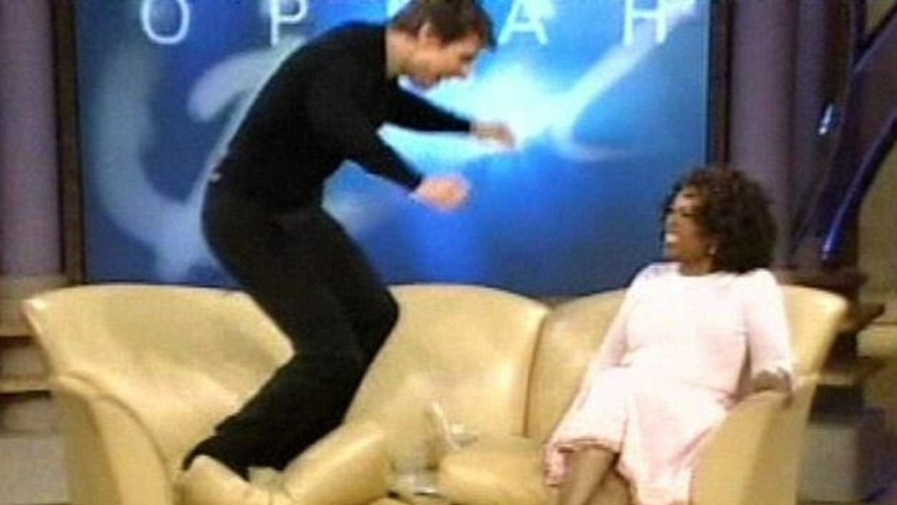 Tom Cruise jumps on the couch after proclaiming his love for actor Katie Holmes as host Oprah Winfrey looks on