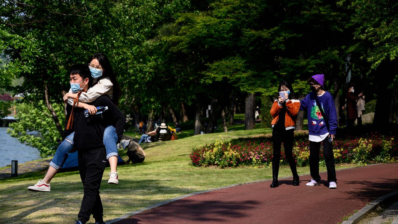 People wearing face masks walk inside the East Lake Plum Flower Garden in Wuhan in China's central Hubei province on April 12, 2020. Picture: Noel Celis/AFP