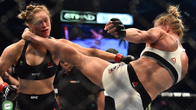 Holly Holm of the US (R) lands a kick to the neck to knock out compatriot Ronda Rousey and win the UFC title fight in Melbourne on November 15, 2015. RESTRICTED TO EDITORIAL USE NO ADVERTISING USE NO PROMOTIONAL USE NO MERCHANDISING USE. AFP PHOTO/Paul CROCK