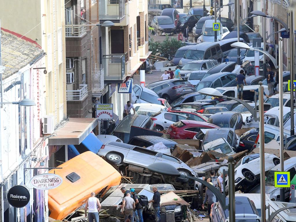 Pile up: Pedestrians stand next to piled up cars following deadly floods in Sedavi, south of Valencia, eastern Spain, on October 30, 2024. Picture: AFP