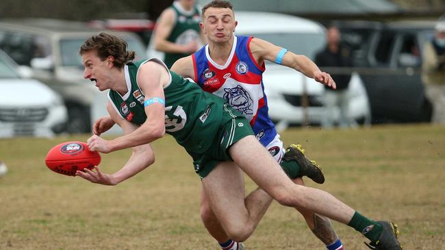 NFL: Greensborough’s Tom Brindley handballs under pressure from Brock Chircop of North Heidelberg. Picture: Hamish Blair