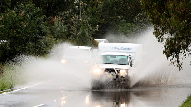 A 4WD and caravan drive through a flooded part of Forest Way in Belrose. Picture: NewsWire / Damian Shaw