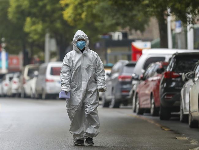 Medical worker in protective gear walks in the street near a health station in Wuhan on Monday. Picture: Chinatopix via AP.