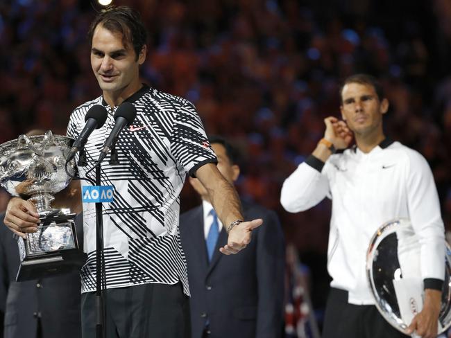 Switzerland's Roger Federer addresses the spectators, holding his trophy, after defeating Spain's Rafael Nadal (background).