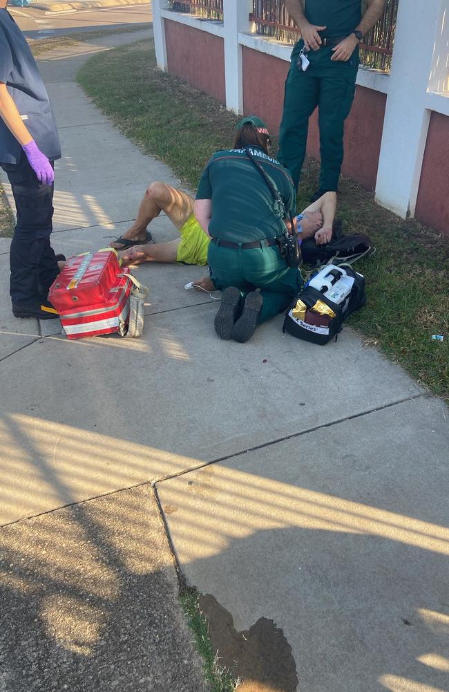 The elderly dog owner is treated by ambulance officers after the incident.