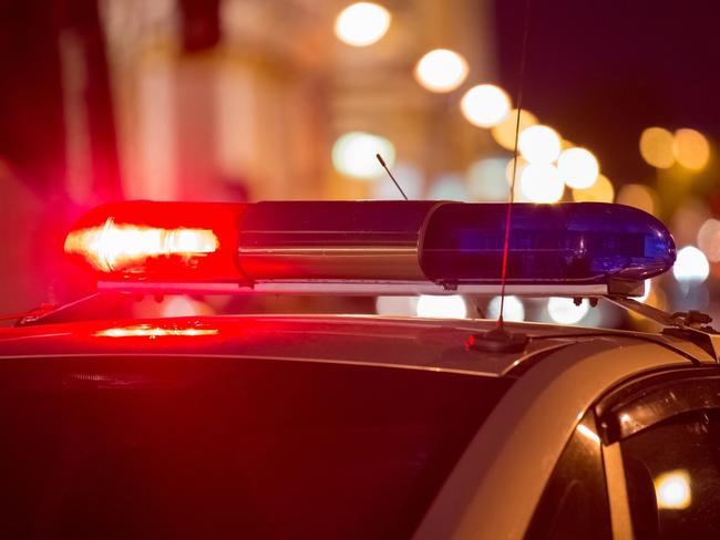 Red light flasher atop of a police car. City lights on the background.