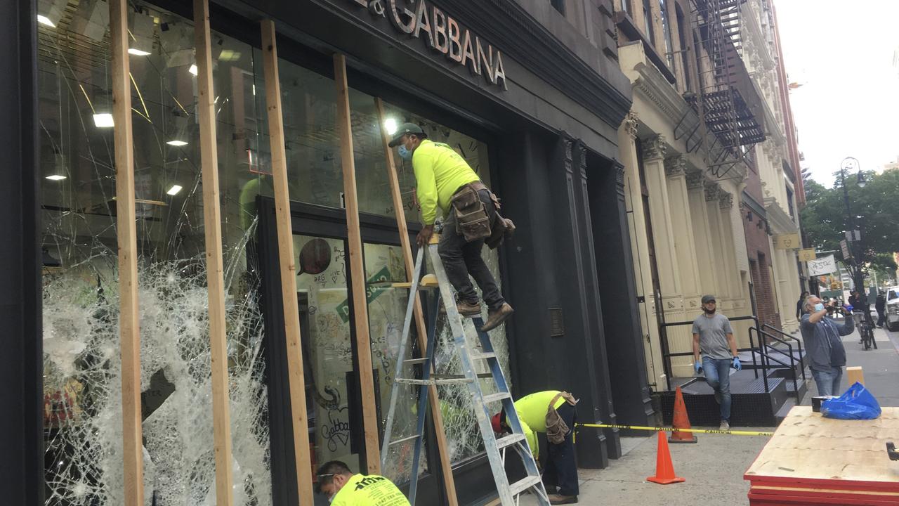 Workers assess damage at a designer clothing store. Picture: STRF/STAR MAX/IPx