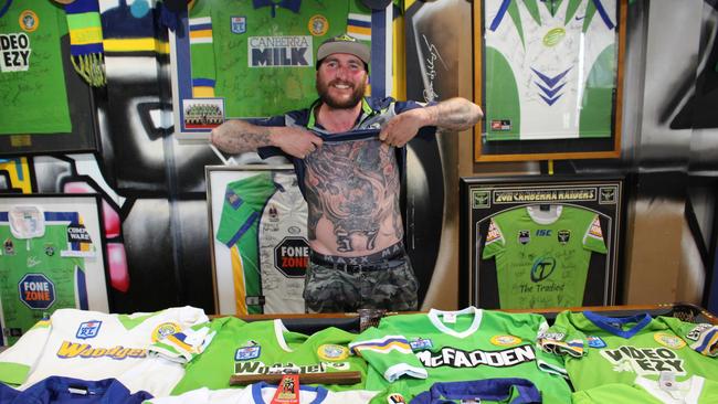 Canberra Raiders superfan Peter “Nugget” Osborne with some of his jerseys and the Viking tattoo on his torso. Picture: Kate Christian