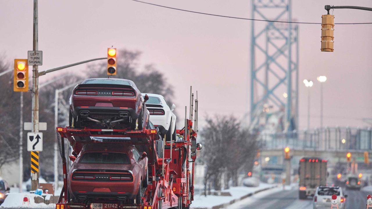 Trucks drive down the road towards the Ambassador Bridge after the border crossing reopened to traffic. Picture: AFP.