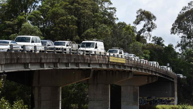 Locals at Tumbulgum park their cars on high ground on the bridge as flooding and wild weather battered the region this week. Picture: NCA NewsWire / Steve Holland