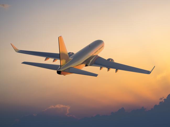 Passanger airplane flying above clouds in evening.