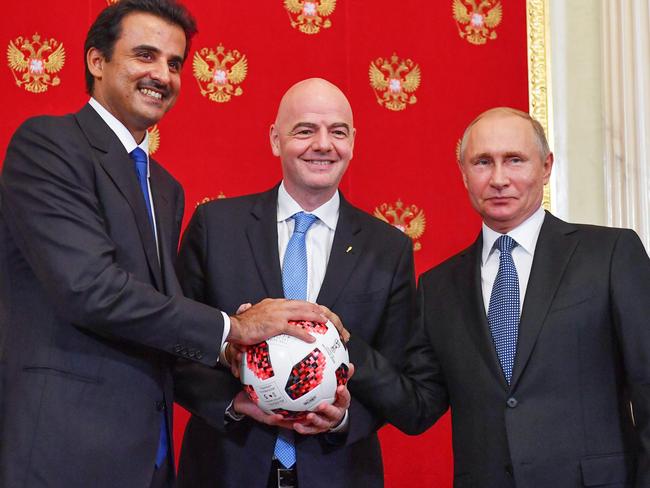 (From L) Emir of Qatar Sheikh Tamim bin Hamad Al-Thani, FIFA President Gianni Infantino and Russian President Vladimir Putin pose for a photography during a symbolic transfer of the authority to Qatar to host the World Cup 2022 at the Kremlin in Moscow on July 15, 2018. / AFP PHOTO / POOL / Yuri KADOBNOV