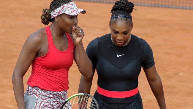 Venus Williams (L) and Serena Williams of the US talk prior to the start of their women's doubles