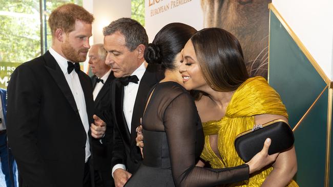 Harry chats with Disney CEO Robert Iger as Meghan embraces Beyonce Knowles-Carter at the European Premiere of Disney's "The Lion King" in 2019.