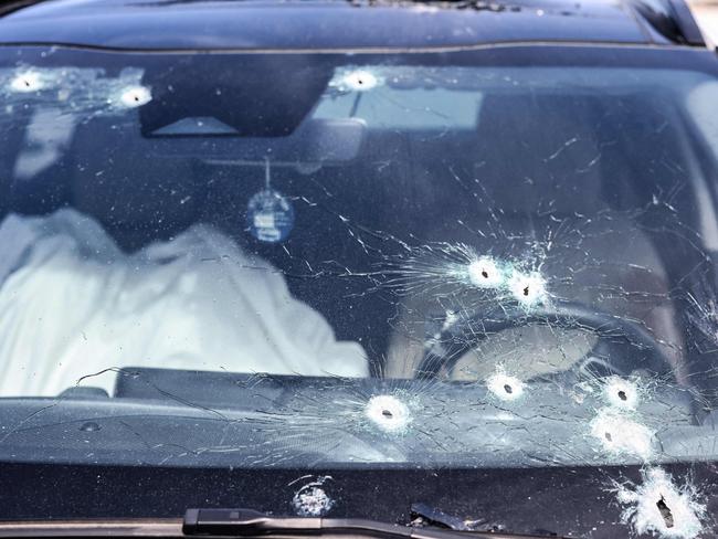 A body lies covered inside a bullet-riddled car in the southern city of Sderot on October 7, 2023. Picture: AFP