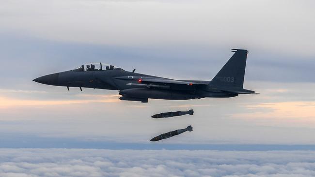 A South Korean Air Force F-15K dropping bombs against a target at the Jikdo shooting field in the Yellow Sea in response to North Korea firing a missile over Japan. Picture: AFP