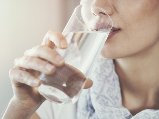 Young woman drinking pure glass of water