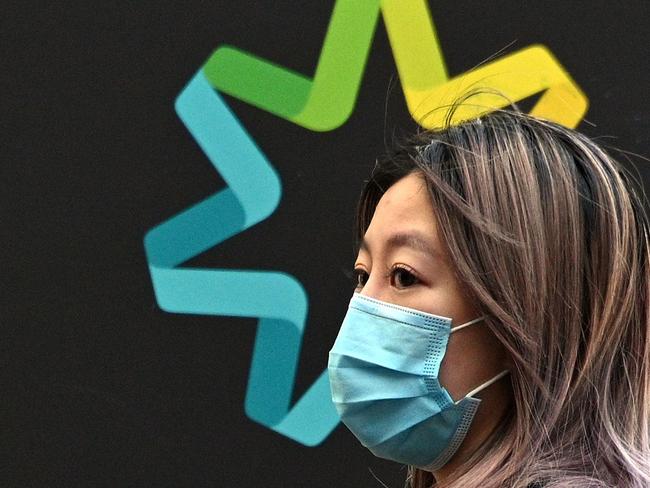 A woman waits in a queue to receive benefit payouts, including unemployment and small business support, at a Centerlink payment centre in downtown Sydney on April 14, 2020. - Australia's unemployment rate is expected to soar from 5.1 percent to 10 percent in the June quarter as the coronavirus fallout hits the economy, according to Treasury figures released on April 14. (Photo by Saeed KHAN / AFP)