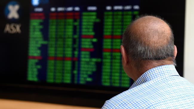 A man watches the shares prices listed at the ASX in Sydney.