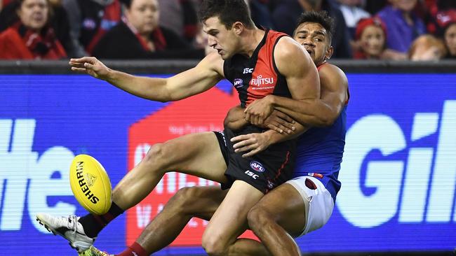 Jackson Merrett gets a kick away while being tackled by Neville Jetta.