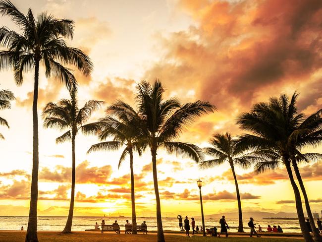 Typical picturesque sunset along Waikiki Beach with hundreds gathering to watch. Picture: iStockAmanda Woods, Escape, hawaii