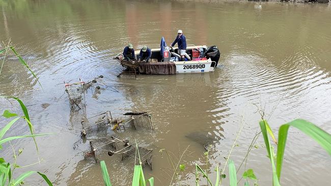 Crews begin work to remove more than thirty shopping trolleys dumped in the Bremer River at Riverlink.