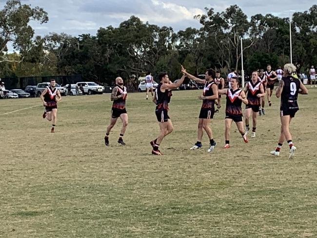 Brett Deledio is congratulated by Devon Meadows teammates after kicking a goal.