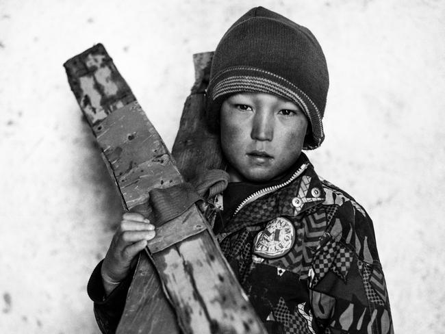 Image Name: 20170302_Quilty_Bmyn_Afg_207-Edit.jpgPhotographer Name: Andrew QuiltyOmid, who doesn't know his age, stands for a portrait with his homemade skis in Aub Bala's village mosque. Aub Bala, 'High Water', is the farthest village up the Fuladi Valley in central Afghanistan's Bamiyan Province, so named because it is the closest to the source of the valley's water, which comes off the mountains in snow-melt and rain, deeper in the valley, beyond where the single road reaches.Series Name: High Water Skiing first came to Aub Bala in 2009, when two staff members of the Agha Khan Foundation visited the village while mapping Bamiyan's snowfields for the purpose of producing a guide book for skiers. Since then, boys in the village have built their own based on what they remember of the visitors' equipment.Copyright: © Andrew Quilty, Australia, Shortlist, Professional, Portraiture (Professional competition), 2018 Sony World Photography Awards