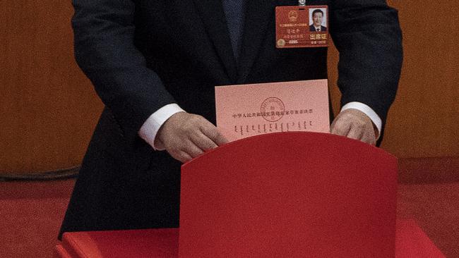 Mr Xi places his ballot in a box during a vote on an amendment to the constitution. Picture: Kevin Frayer/Getty Images