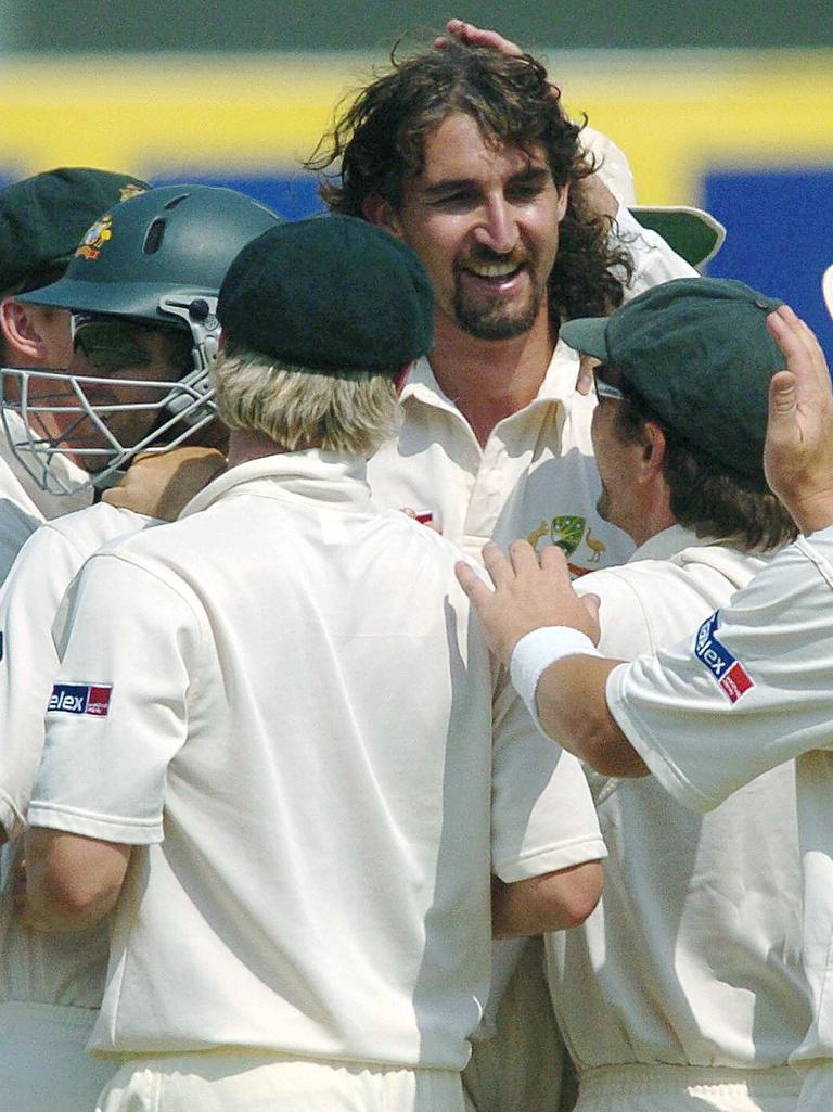 Gillespie is mobbed by teammates after taking a wicket.