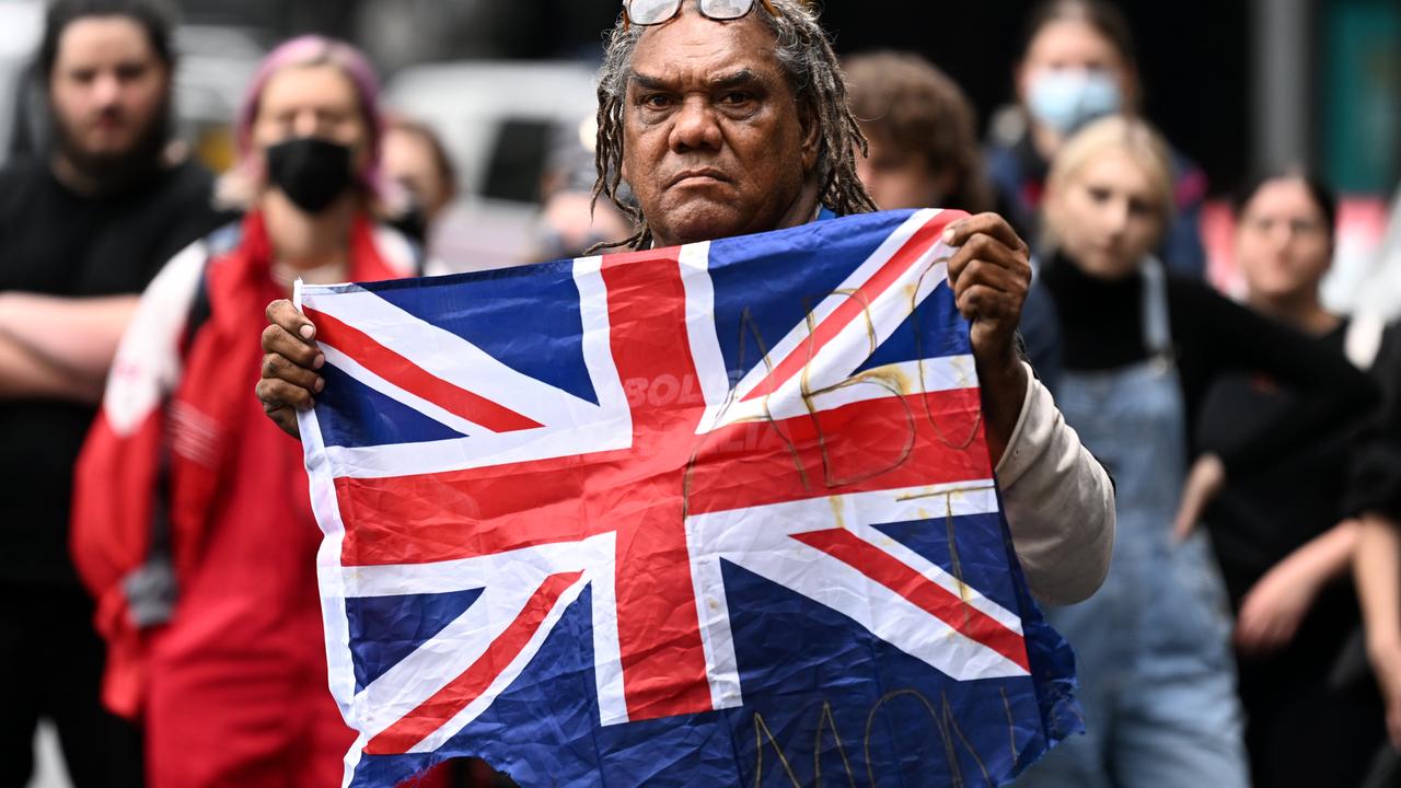 A First Nations protester holds the British flag before burning it during an anti-monarchy rally. Picture: NCA NewsWire / Dan Peled