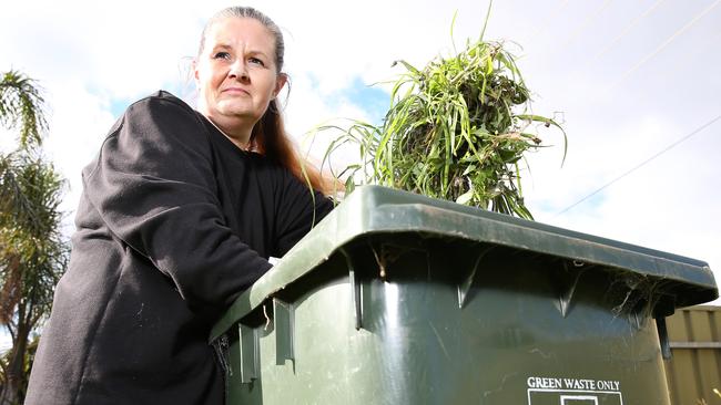 Jenny Clark of Port Noarlunga South with her green waste bin, which she would like collected twice a month. Picture: Stephen Laffer