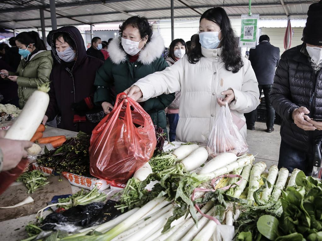 Resident wear masks to buy vegetables in Wuhan, which has been placed into lockdown as Chinese authorities try to contain the outbreak. Picture: Getty Images