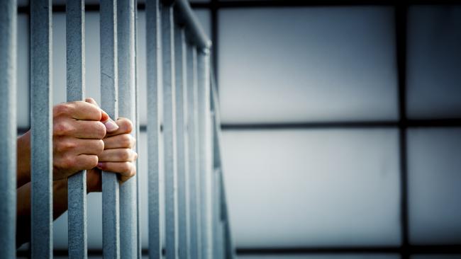 Generic photo of hands in jail cell.