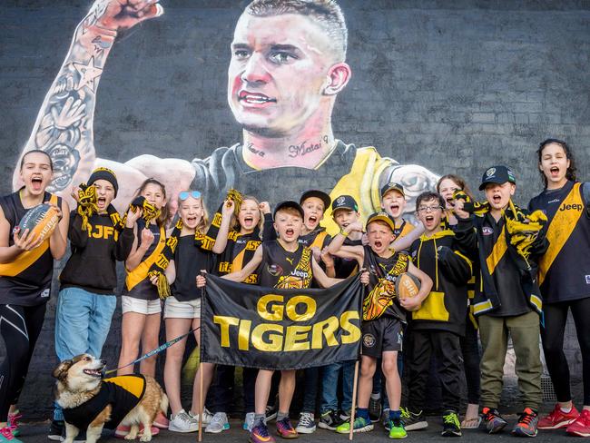 Young Richmond fans celebrate the Dustin Martin mural that was painted overnight after his Brownlow Medal win. Picture: Jake Nowakowski